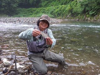 ヤマメを釣り上げ、笑みがこぼれるシマノの遠藤さんの写真